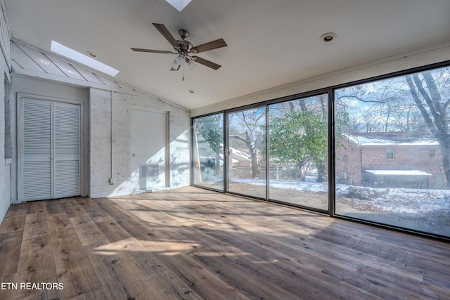 interior space with vaulted ceiling with skylight and a ceiling fan