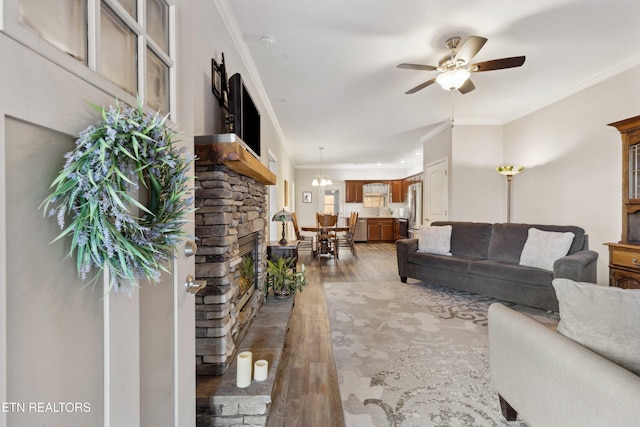 living room with ornamental molding, ceiling fan, and wood finished floors