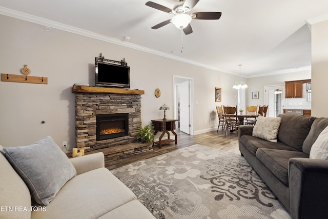 living area featuring light wood-type flooring, a fireplace, and crown molding