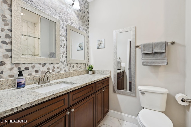 bathroom with baseboards, toilet, a shower with shower door, marble finish floor, and vanity