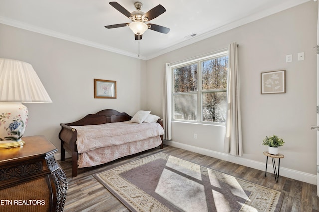 bedroom with wood finished floors, a ceiling fan, visible vents, baseboards, and ornamental molding