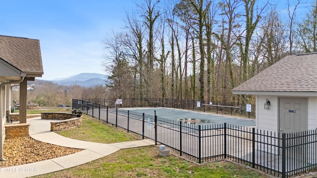 exterior space featuring a mountain view, a community pool, and fence