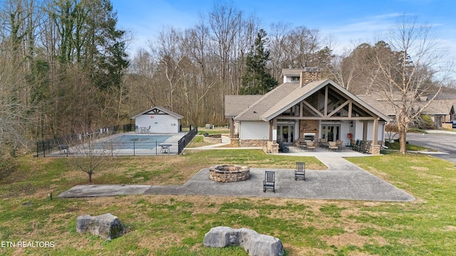 view of home's community with an outdoor structure, an outdoor fire pit, a yard, a patio area, and a pool