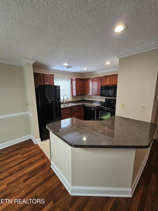 kitchen featuring black appliances, ornamental molding, a sink, and wood finished floors