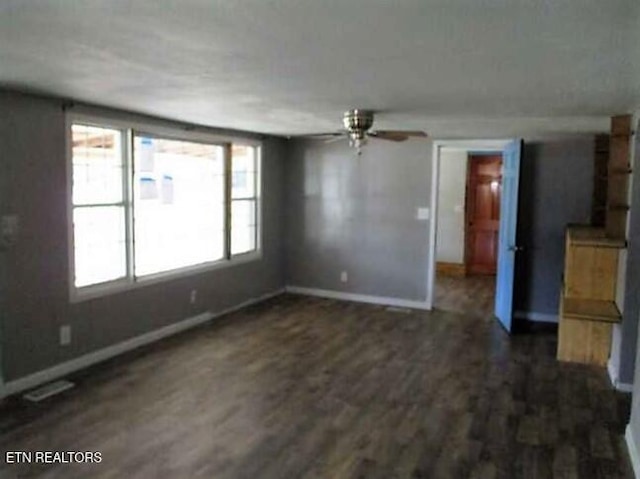 unfurnished living room featuring dark wood finished floors, a ceiling fan, and baseboards