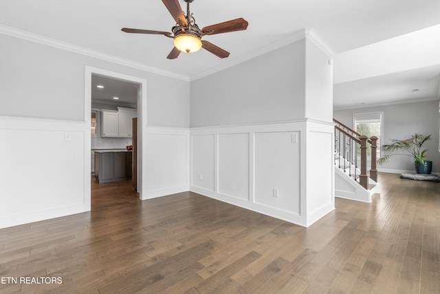 unfurnished room featuring stairs, ornamental molding, and dark wood finished floors