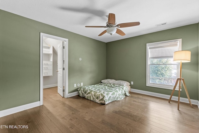 bedroom with visible vents, ceiling fan, baseboards, and wood finished floors