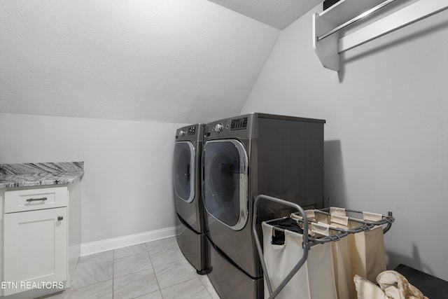 laundry area featuring a textured ceiling, laundry area, baseboards, marble finish floor, and washing machine and clothes dryer