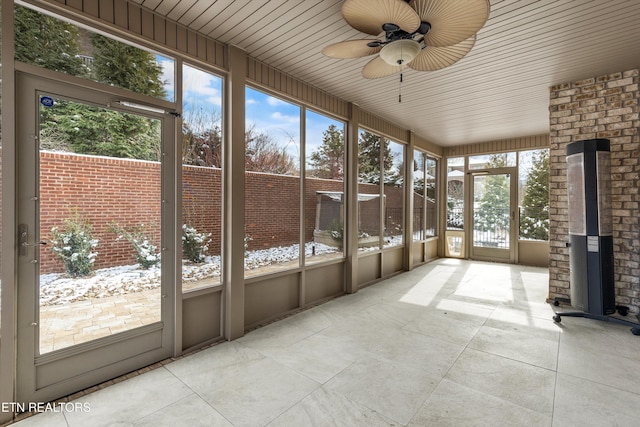 unfurnished sunroom featuring a ceiling fan and wood ceiling