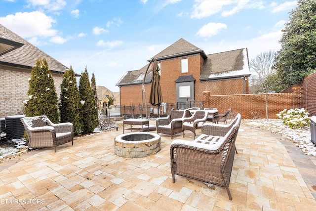 view of patio / terrace with central AC unit, fence, and an outdoor living space with a fire pit