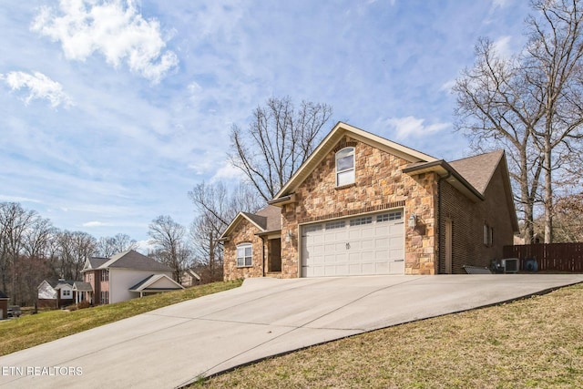 traditional home with concrete driveway, stone siding, fence, cooling unit, and a front yard