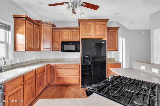 kitchen featuring black appliances, a sink, and light countertops