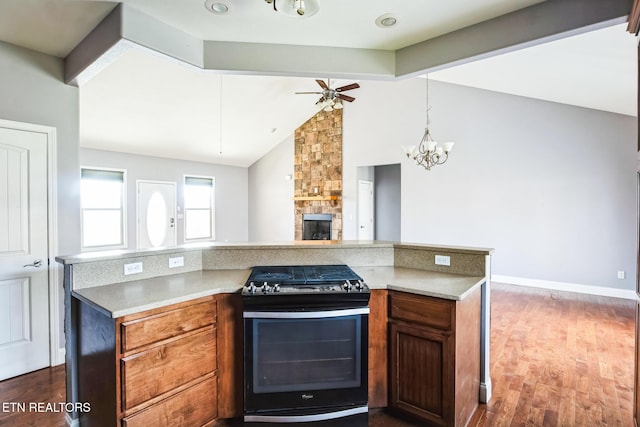 kitchen featuring range with gas stovetop, dark wood-style flooring, vaulted ceiling with beams, open floor plan, and a stone fireplace