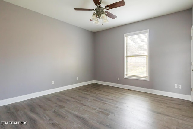 unfurnished room featuring ceiling fan, wood finished floors, and baseboards