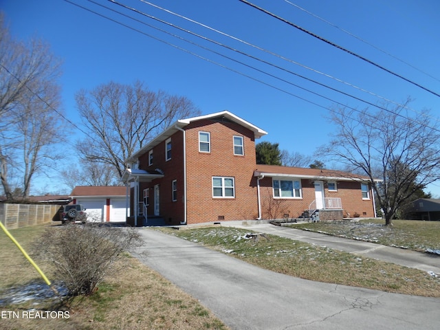 traditional home with driveway, brick siding, and crawl space