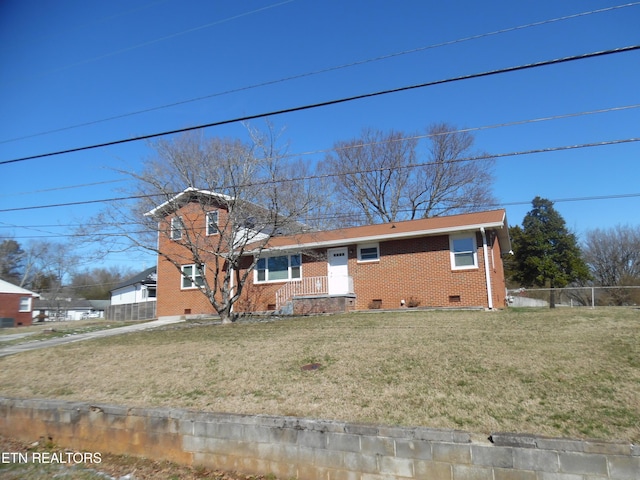 view of front of property featuring brick siding, crawl space, a front lawn, and fence