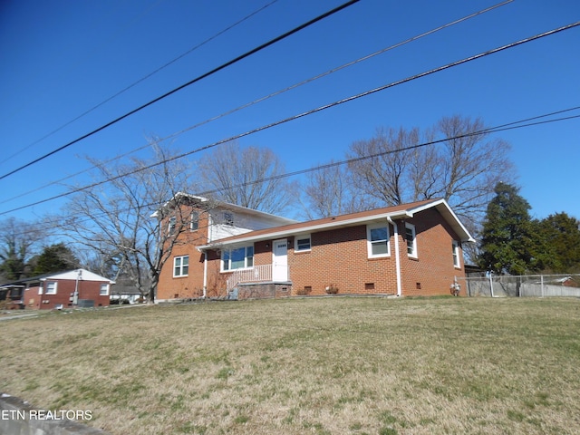 exterior space featuring crawl space, fence, a lawn, and brick siding