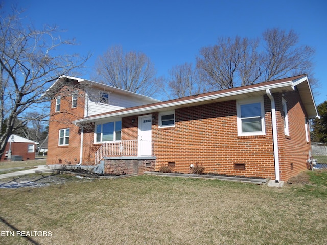 view of front facade with crawl space, a front lawn, and brick siding