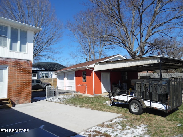 view of side of home featuring a detached garage, an outdoor structure, and brick siding