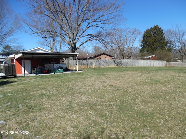 view of yard with a carport and fence