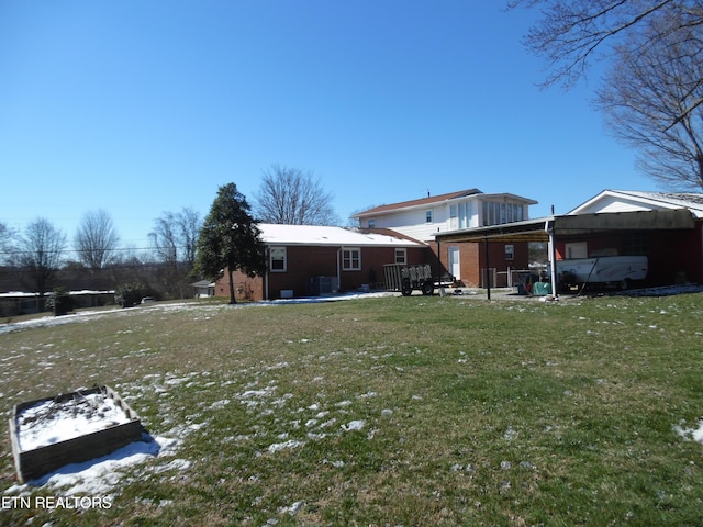 rear view of house with a carport and a yard