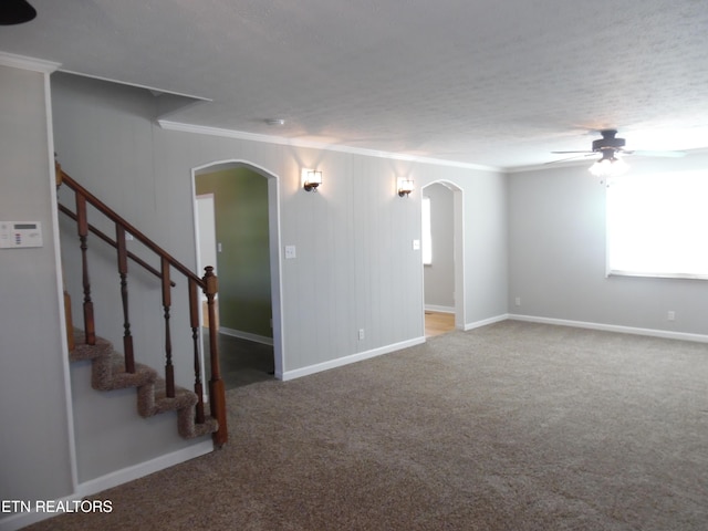 spare room featuring arched walkways, carpet floors, stairs, and crown molding