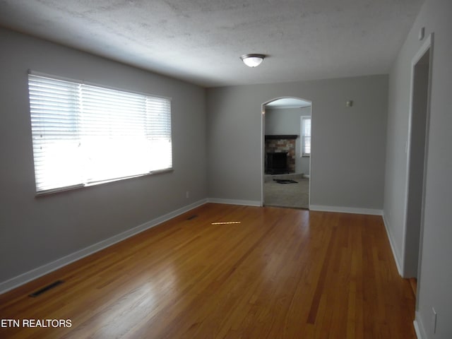 unfurnished room with a fireplace, wood finished floors, and baseboards