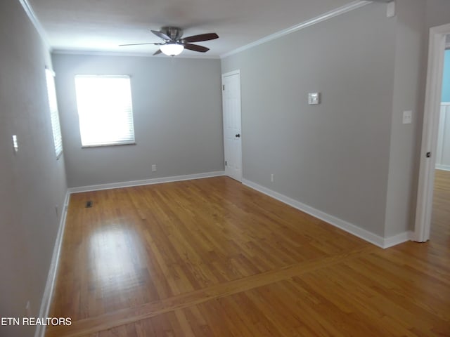 unfurnished room featuring baseboards, ceiling fan, wood finished floors, and crown molding