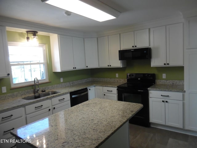 kitchen featuring light stone counters, white cabinetry, a sink, and black appliances