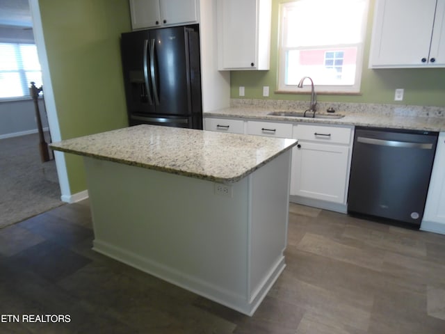 kitchen featuring dishwasher, a kitchen island, black refrigerator with ice dispenser, white cabinetry, and a sink