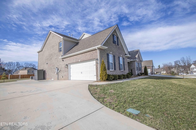 view of side of property with concrete driveway, brick siding, a yard, and fence