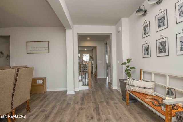 hallway featuring dark wood-type flooring, stairway, and baseboards