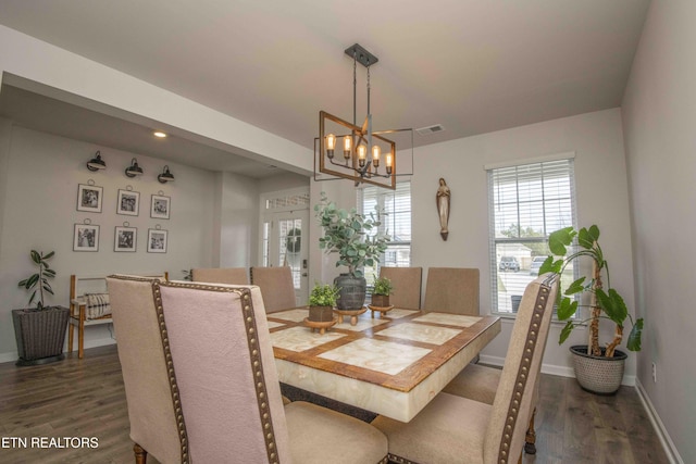 dining area with dark wood-type flooring, a chandelier, visible vents, and baseboards