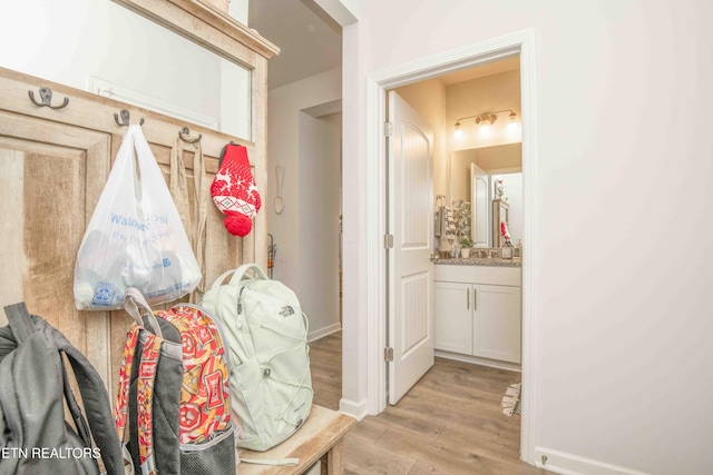 mudroom featuring light wood-style flooring and baseboards