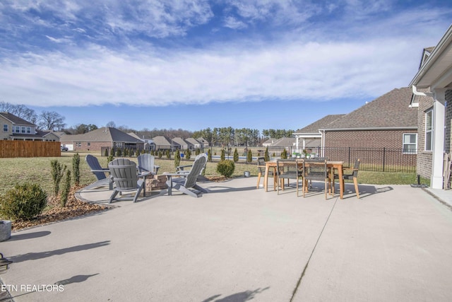 view of patio featuring outdoor dining area, a residential view, a fire pit, and fence