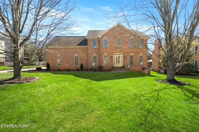 view of front of property with a front lawn and brick siding