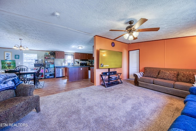 carpeted living area with wood finished floors, a textured ceiling, and ceiling fan with notable chandelier