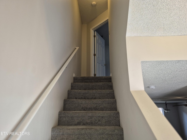 stairs with a textured ceiling