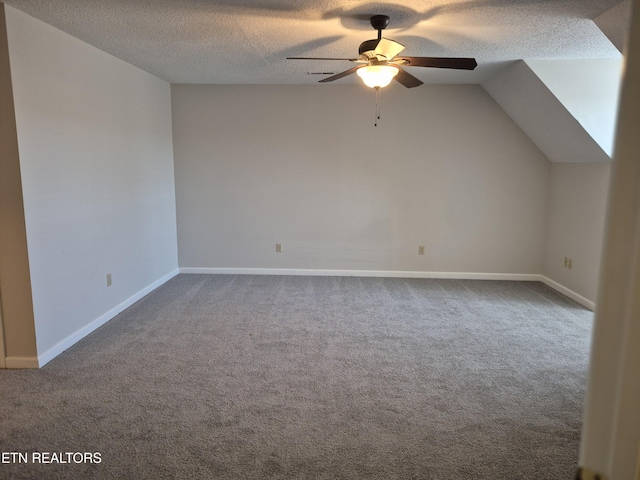 additional living space featuring carpet floors, vaulted ceiling, a textured ceiling, and ceiling fan