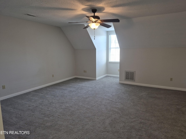 bonus room with a textured ceiling, vaulted ceiling, and visible vents