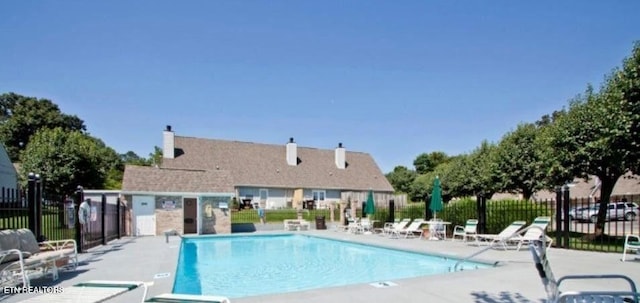 community pool featuring a patio area and fence