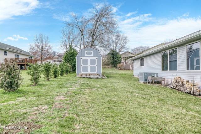 view of yard with cooling unit, an outdoor structure, a wooden deck, and a storage unit