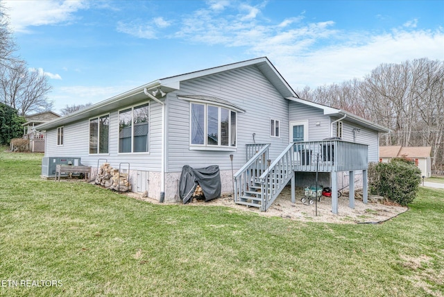 rear view of property with stairway, a lawn, and a wooden deck