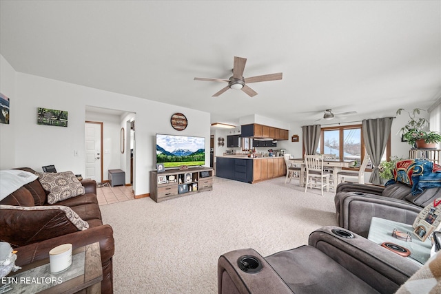 living room featuring light carpet, a ceiling fan, and baseboards