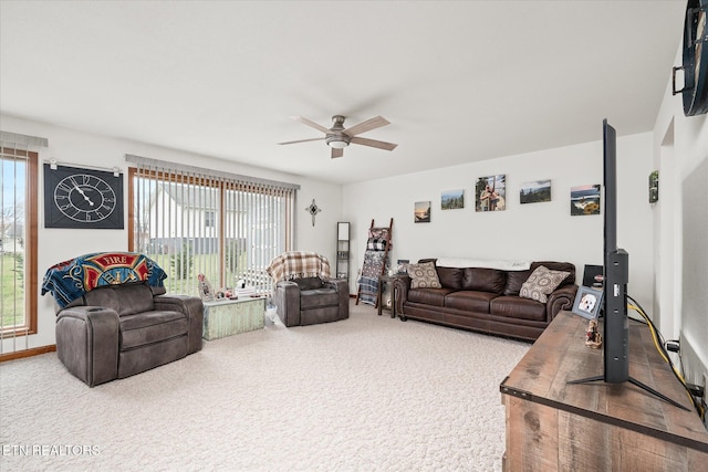 carpeted living area with a healthy amount of sunlight, baseboards, and a ceiling fan