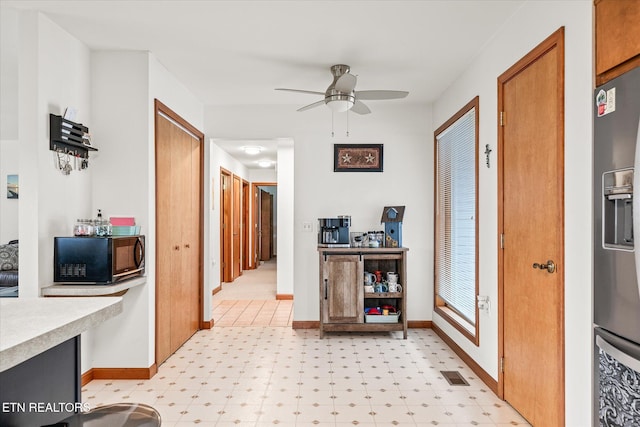 corridor featuring light floors, visible vents, and baseboards