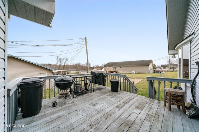 wooden deck with a lawn and area for grilling