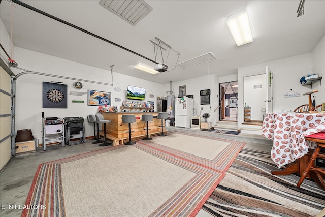 garage with a garage door opener and freestanding refrigerator