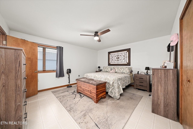 bedroom featuring baseboards, ceiling fan, and light floors