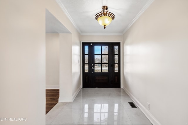 foyer featuring crown molding, visible vents, and baseboards